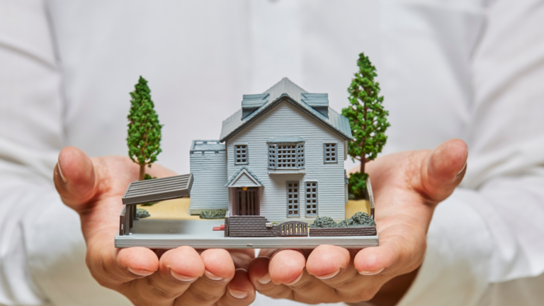 Hands holding a model home, representing downsizing options for seniors and their families