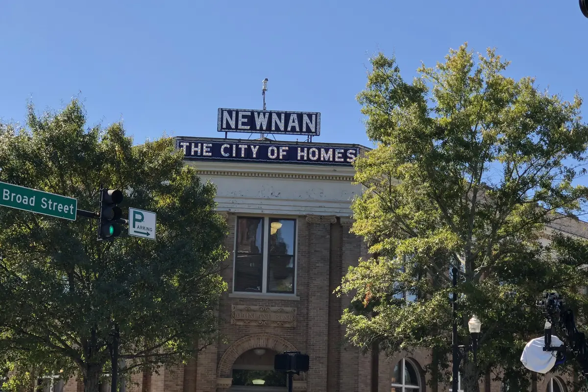 Newnan The City of Homes sign above a historic brick building on Broad Street in downtown Newnan, Georgia