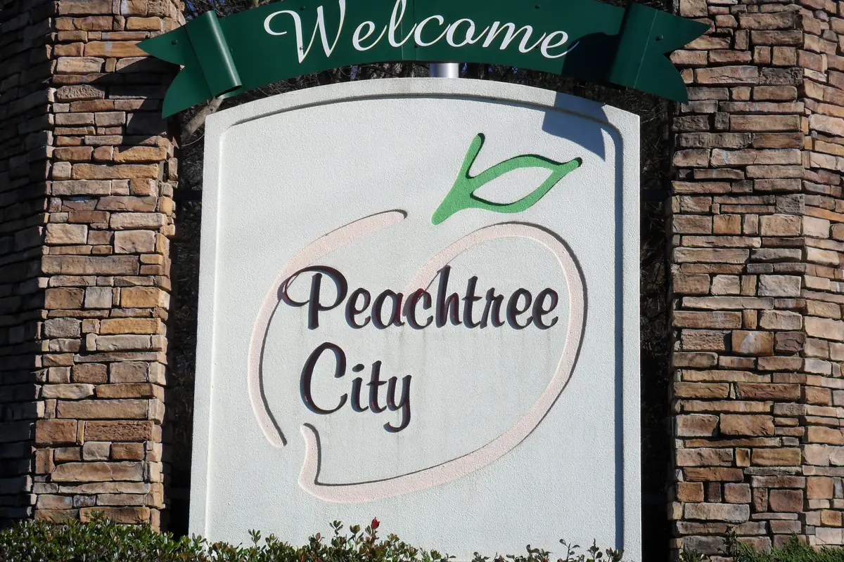 Welcome to Peachtree City sign with a peach logo, Peachtree City, Georgia
