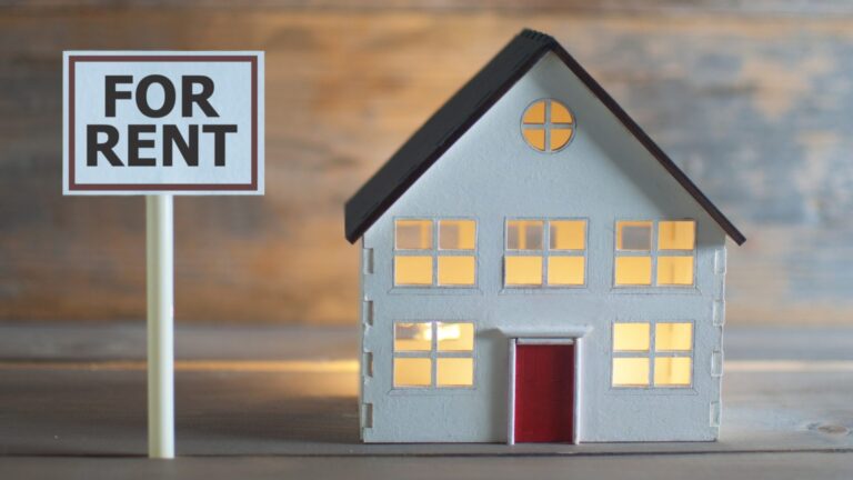 For Rent sign beside a model house, illustrating whether a rental property is making money